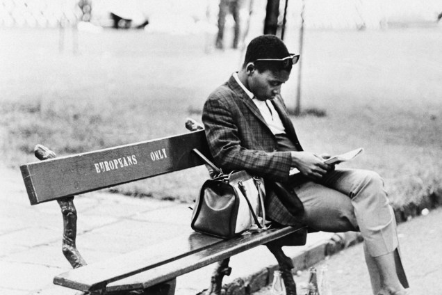 Homem negro senta em banco com os dizeres 'Europeus apenas', em um parque da África do Sul -  02/05/1970