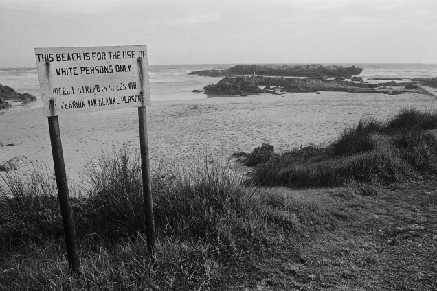 Placa com os dizeres "Esta praia é para o uso de pessoas brancas apenas" é vista em uma praia nos arredores de Hermanus, na África do Sul - 01/12/1974