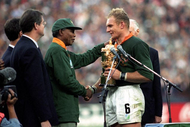 Francois Pienaar, então jogador de rúgbi sul-africano, recebe troféu do líder do país, Nelson Mandela, após a final do campeonato realizado no Estádio Ellis Park, localizado em Joanesburgo - 24/06/1995