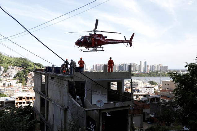 Pessoa em uma maca é transportada em um helicóptero depois que um prédio desmoronou na comunidade de Muzema, no Rio de Janeiro - 12/04/2019