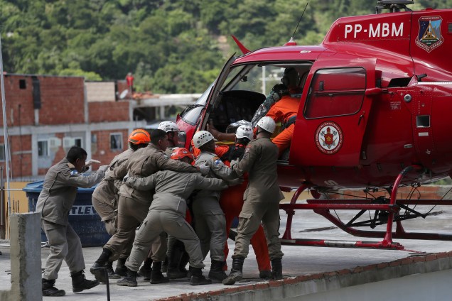 Homem em uma maca é carregado para um helicóptero no local do desabamento de dois prédios na comunidade da Muzema, Rio de Janeiro - 12/04/2019