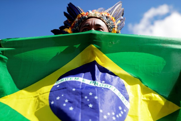 Índio é visto com bandeira do Brasil durante protesto contra o governo no acampamento Terra Livre, montado nos arredores do Congresso Nacional, em Brasília (DF) - 26/04/2019