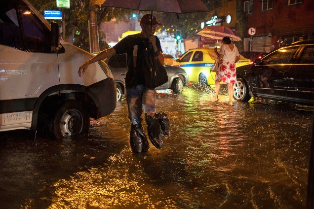 Pedestres atravessam enchente na rua Mena Barreto, no bairro do Botafogo, localizado no Rio de Janeiro (RJ) - 08/04/2019