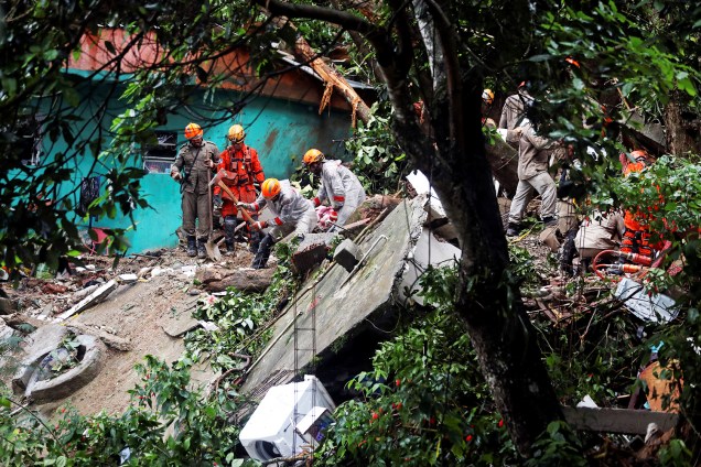 Membros da Defesa Civil e do Corpo de Bombeiros retiram escombros de residência após forte temporal atingir o Rio de Janeiro - 09/04/2019