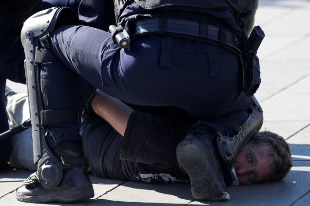 Policial detém um manifestante durante um protesto dos Coletes Amarelos em Paris, na França - 20/04/2019