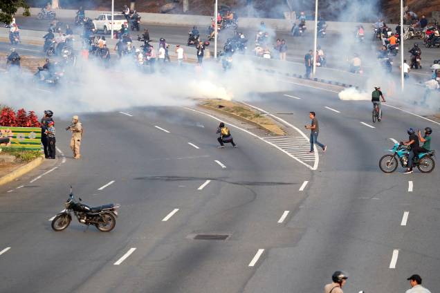 Pessoas reagem ao gás lacrimogêneo durante confrontos nos arredores da base aérea "La Carlota", em Caracas, Venezuela - 30/04/2019