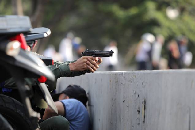 Militar aponta uma arma durante manifestações nos arredores da Base Aérea "La Carlota", em Caracas, na Venezuela - 30/04/2019