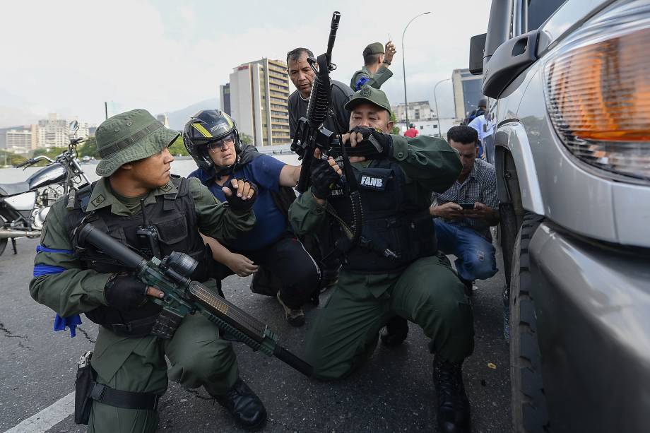 Membros da Força Armada Nacional Bolivariana (FANB) que apoiam o líder da oposição Juan Guaidó se posicionam em frente à base de La Carlota, em Caracas - 30/04/2019