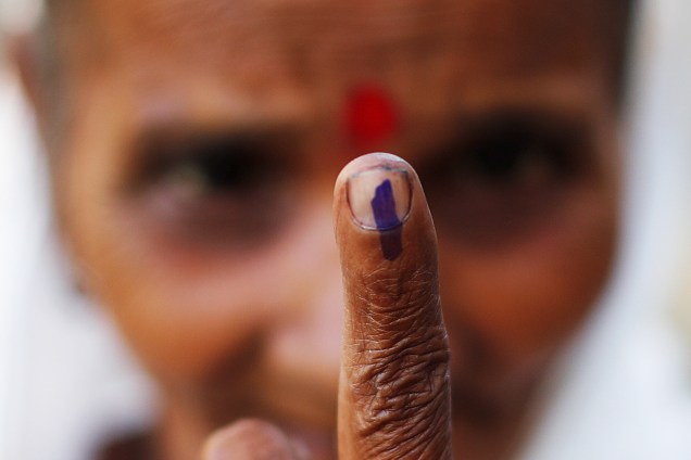Mulher exibe marcação no dedo após votar em Majuli, Índia - 11/04/2019