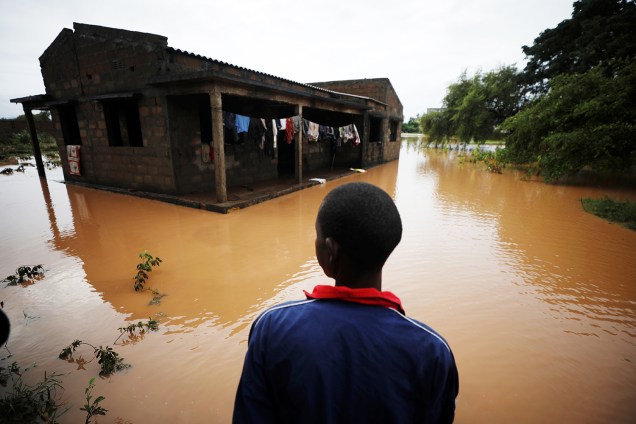 Garoto observa casa inundada após a passagem do ciclone Kenneth, no vilarejo de Wimbe, localizado na cidade de Pemba, em Moçambique - 29/04/2019