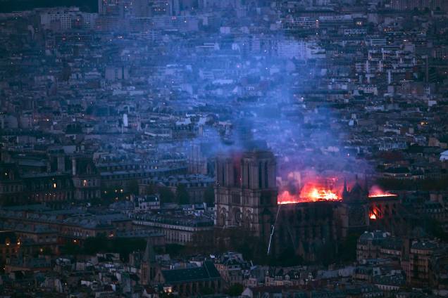 Vista geral da Torre Montparnasse mostra chamas e fumaça sobre o teto da Catedral de Notre-Dame, em Paris - 15/04/2019
