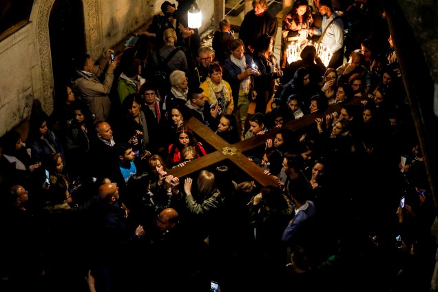 Fiéis cristãos carregam uma cruz de madeira para a Igreja do Santo Sepulcro durante a procissão da Sexta-Feira Santa ao longo da Via Dolorosa na Cidade Velha de Jerusalém - 19/04/2019