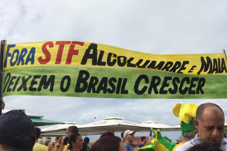Manifestante carrega faixa durante protesto a favor do governo Bolsonaro nos arredores da Praia de Copacabana, no Rio de Janeiro (RJ) - 26/05/2019 Manifestante carrega faixa durante protesto a favor do governo Bolsonaro nos arredores da Praia de Copacabana, no Rio de Janeiro (RJ) - 26/05/2019