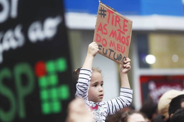 Criança exibe placa com os dizeres "Tire as mãos do meu futuro" , durante protesto contra os cortes na área da educação e pesquisa anunciados pelo Governo Federal, na avenida Paulista, em São Paulo (SP) - 15/05/2019