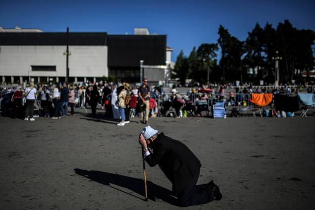 Homem se ajoelha para rezar diante do Santuário de Fátima durante as celebrações da padroeira de Portugal Homem se ajoelha para rezar diante do Santuário de Fátima durante as celebrações da padroeira de Portugal