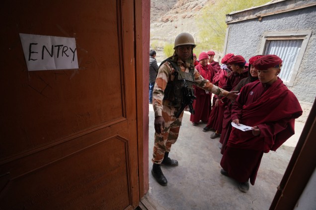 Soldado orienta monge budista em local de votação próximo do Monastério de Hemi, na região de Ladakh, Índia - 06/05/2019