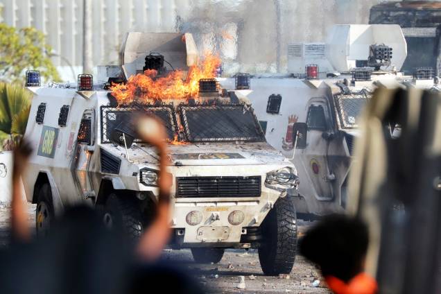 Manifestantes colocam fogo em veículo militar durante confronto em Caracas, capital da Venezuela - 01/05/2019