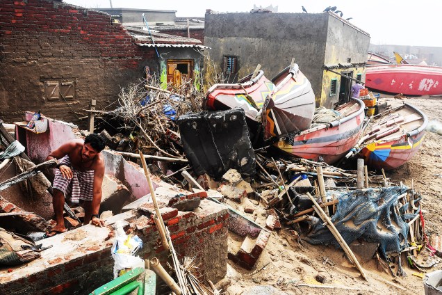 Homem caminha entre escombros de residência após a passagem do ciclone Fani na cidade de Puri, localizada no estado indiano de Odisha - 04/05/2019