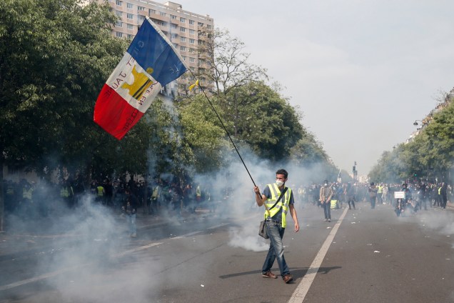Manifestante com colete amarelo carrega bandeira francesa durante protesto do Dia do Trabalho, em Paris - 01/05/2019