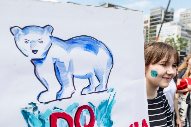 Garota segura cartaz com urso desenhado,  durante protesto contra mudanças climáticas realizado em Varsóvia, capital da Polônia - 24/05/2019