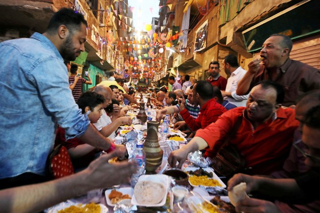 Moradores de Ezbet Hamada, no Cairo, se alimentam após o pôr do sol, durante o mês do jejum sagrado do Ramadã - 20/05/2019