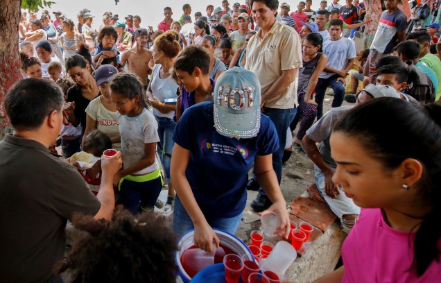 Migrantes venezuelanos recebem alimentos próximos da ponte Simón Bolívar, em Cúcuta, na Colômbia - 01/05/2019