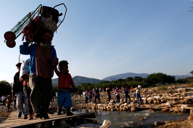 Migrantes atravessam o rio Táchira, próximo da fronteira entre Colômbia e a Venezuela, nos arredores da cidade de Cúcuta - 02/05/2019