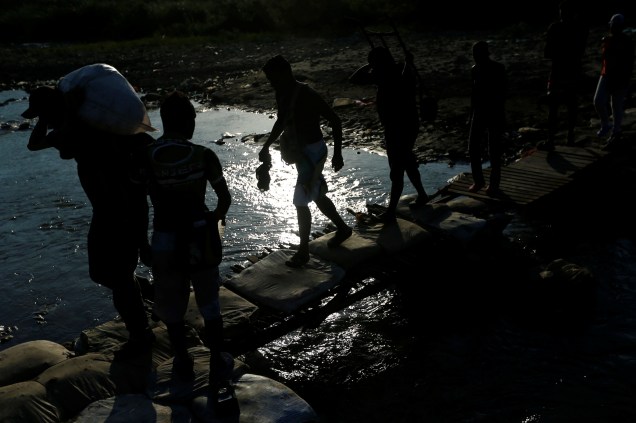 Migrantes atravessam o rio Táchira, próximo da fronteira entre Colômbia e a Venezuela, nos arredores da cidade de Cúcuta - 02/05/2019