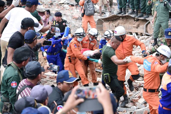 Rescue team carries a wounded worker at a collapsed building in Sihanoukville
