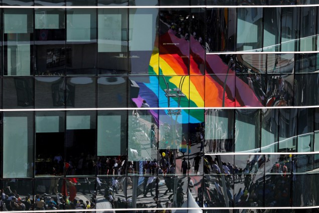 Participantes são vistos refletidos em prédio na 23ª edição da Parada do Orgulho LGBT na Avenida Paulista, <span>considerada a maior do mundo, reuniu 3 milhões de pessoas neste domingo </span>- 23/06/2019