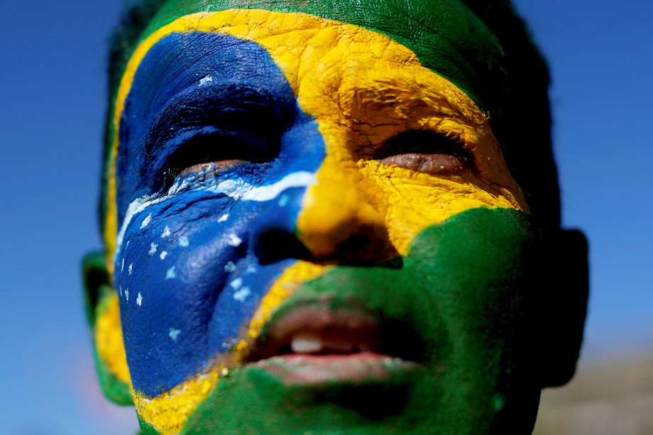 Maanifestante pinta rosto com as cores da bandeira brasileira durante protesto realizado em Brasília (DF) a favor do ministro Sergio Moro e da Operação Lava-Jato - 30/06/2019