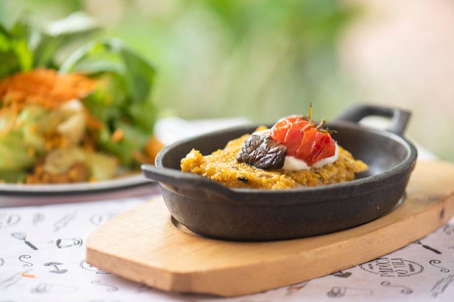 Quibe de abóbora com quinoa: ladeado por uma vistosa salada de folhas verdes, tomate-cereja e granola salgada da casa