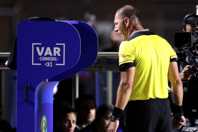 O árbitro Nestor Pitana consulta o VAR durante partida entre Brasil e Bolívia - 14/05/2019