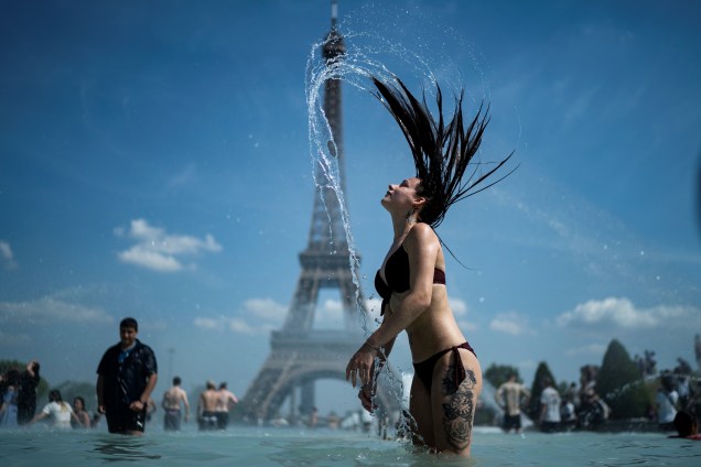 Mulher se refresca na fonte da Esplanada do Trocadero, com a Torre Eiffel ao fundo, em Paris, capital da França - 25/06/2019