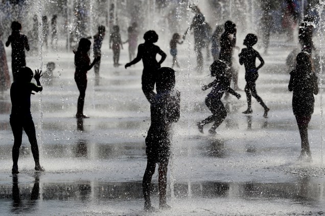 Crianças brincam debaixo de jatos d'água em fonte enquanto se refrescam durante forte onda de calor na cidade de Nice, localizada na França - 26/06/2019