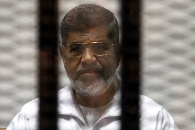 O ex-presidente do Egito, Mohammed Morsi, é visto dentro de uma cela durante seu julgamento em uma academia de polícia do Cairo, no Egito em 2014