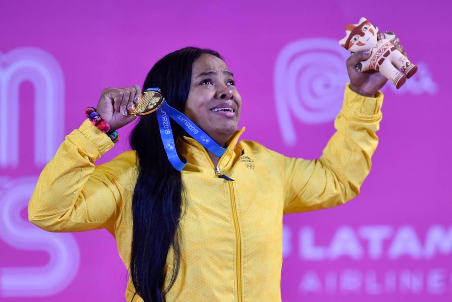 Mercedes Perez, da Colômbia, se emociona no pódio ao conquistar a medalha de ouro no Levantamento de Peso, na categoria até 64kg