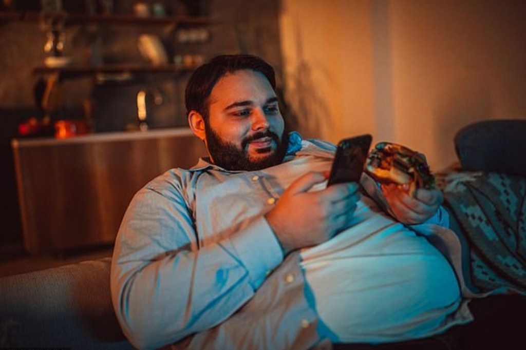 gordo comendo e mexendo no celular