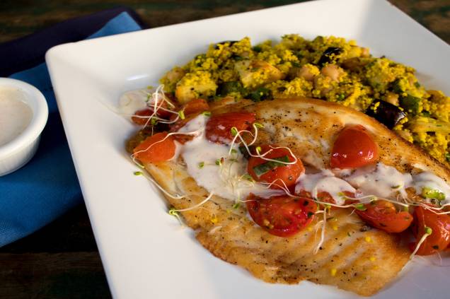 Tilápia ao molho de iogurte picante, couscous com legumes assados e especiarias: prato principal servido no almoço Tilápia ao molho de iogurte picante, couscous com legumes assados e especiarias: prato principal servido no almoço