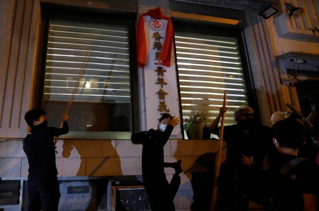 Demonstrators try to attack a building where members of a group opposing the anti-government protesters are supposedly hiding, during a demonstration in support of the city-wide strike and to call for democratic reforms in Hong Kong Demonstrators try to attack a building where members of a group opposing the anti-government protesters are supposedly hiding, during a demonstration in support of the city-wide strike and to call for democratic reforms in Hong Kong