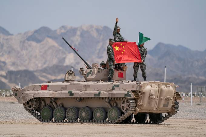 Chinese soldiers of People’s Liberation Army (PLA) pose for photos with a Chinese national flag on a tank during  the Suvorov Attack contest of the International Army Games 2019 in Korla, Xinjiang