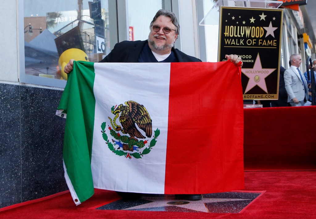 Guillermo del Toro segura a bandeira do México ao receber uma estrela na Calçada da Fama em Hollywood