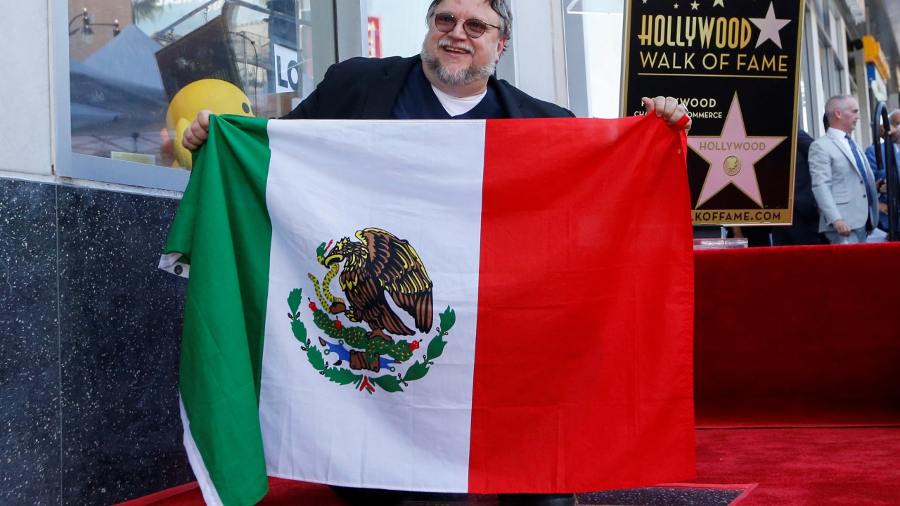Guillermo del Toro segura a bandeira do México ao receber uma estrela na Calçada da Fama em Hollywood
