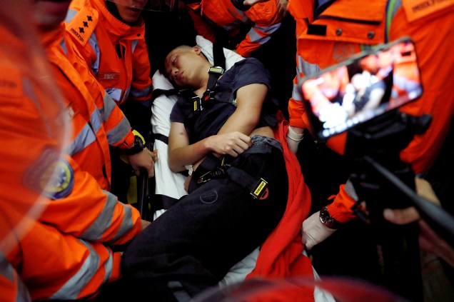 Médicos tentam remover um homem ferido, que os manifestantes anti-governo disseram ser um policial chinês, durante uma manifestação em massa no aeroporto internacional de Hong Kong, na China.