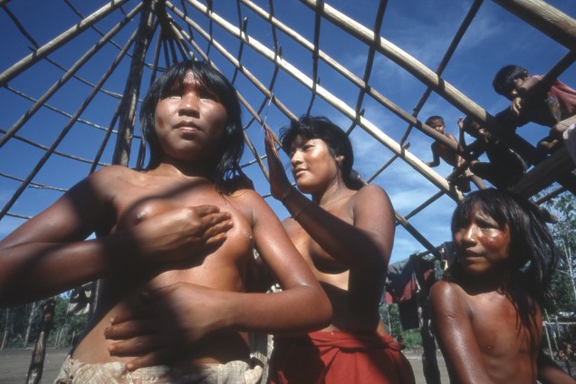 Índias da tribo kaiabi passando urucum contra os mosquitos, aldeia Ilha Grande, no Parque Nacional do Xingu, em 1999