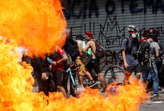 Manifestantes passam por barricada de fogo em Santiago: não à política econômica - 23/10/2019