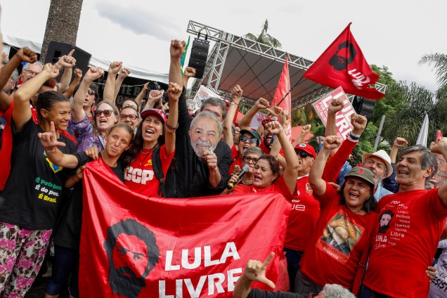 Apoiadores do ex-presidente do Brasil, Luiz Inácio Lula da Silva, fazem um gesto fora da sede da Polícia Federal, onde Lula cumpre pena de prisão, em Curitiba.