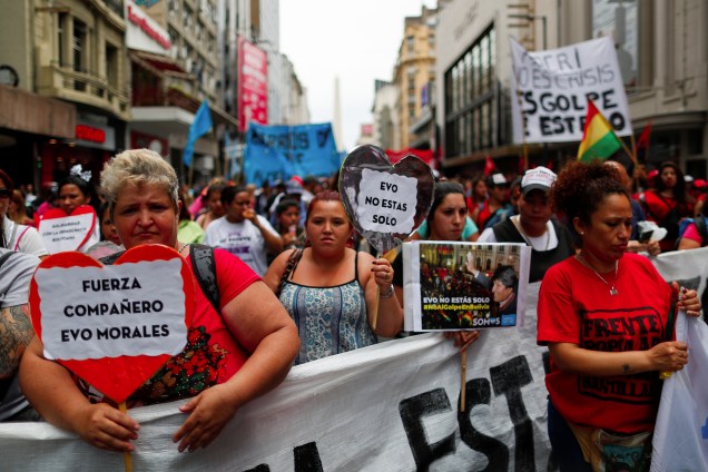 Pessoas segurando cartazes lendo "Força companheiro Evo Morales" e "Você não está sozinho" participam de uma manifestação em apoio ao presidente boliviano Evo Morales depois que ele anunciou sua renúncia no domingo, em Buenos Aires, Argentina.