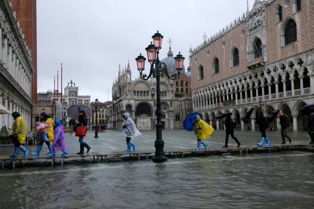Pessoas andando em uma passarela improvisada para evitar a água da maré, Veneza - 12/11/2019