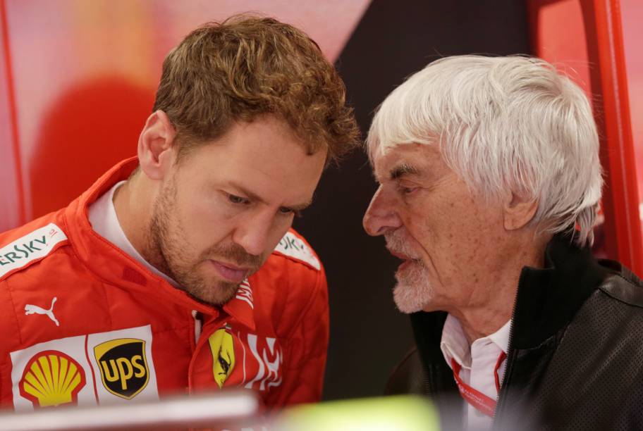 Sebastian Vettel da Ferrari e ex-presidente da F1 Bernard Ecclestone em boxes antes do treino
